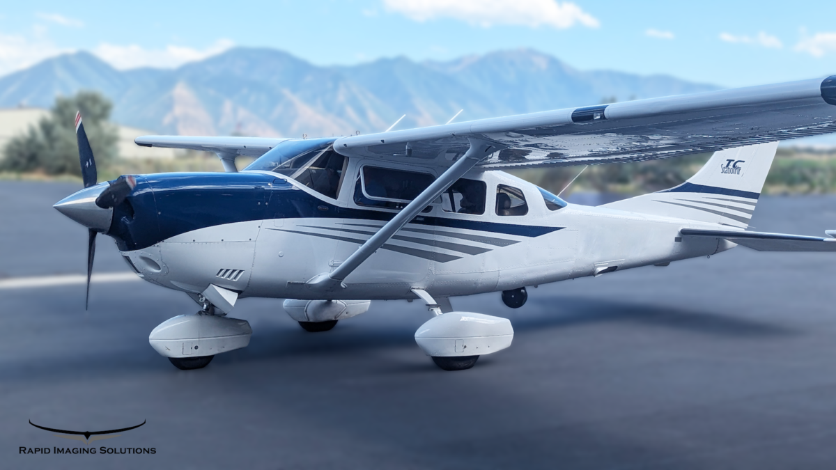 An image of a Cessna 206 with mountains in the background